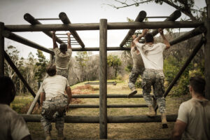 Soldiers climbing monkey bars
