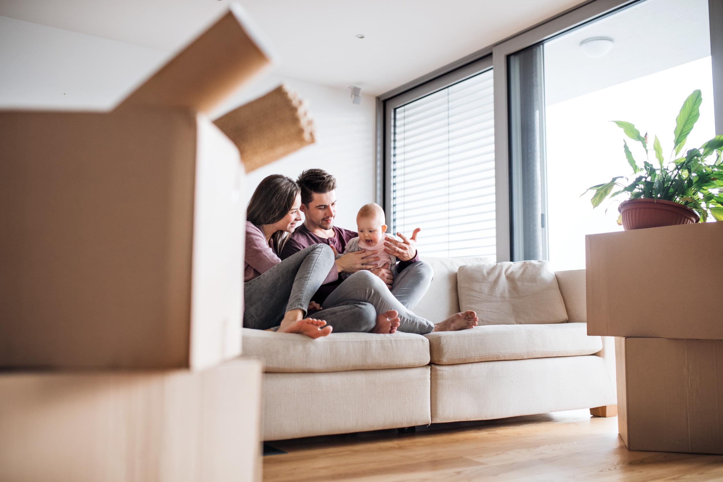 Buying and Selling a Home at the Same Time - Family Sitting on couch with baby