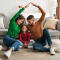 Happy family sitting in their new home, representing the vibrant and growing San Antonio real estate market in 2024.