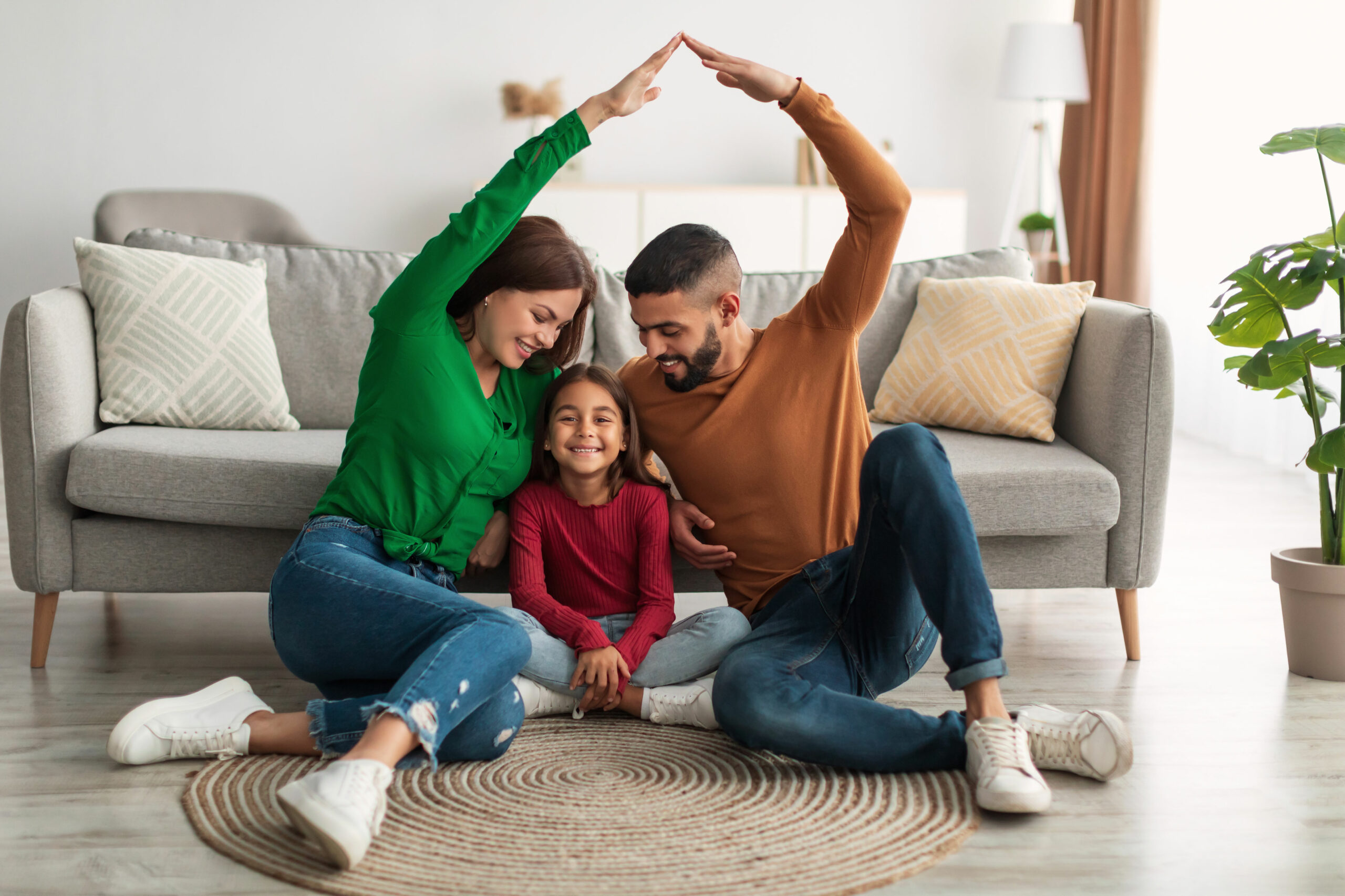 Happy family sitting in their new home, representing the vibrant and growing San Antonio real estate market in 2024.